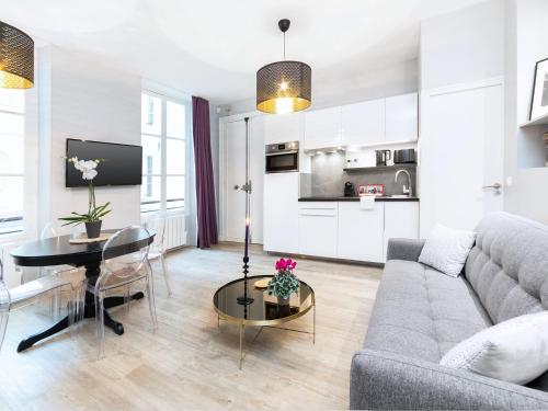 un salon avec un canapé et une table dans l'établissement Chic Apartments Opera, à Paris