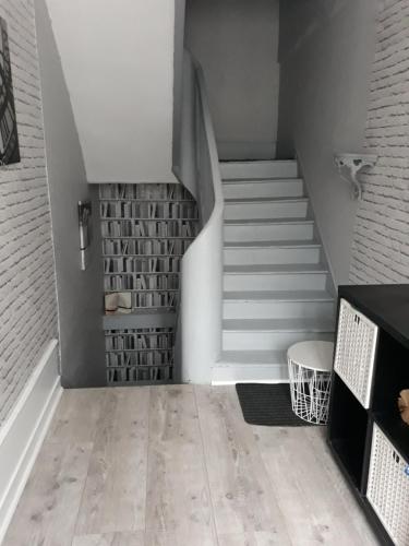 a staircase in a room with white walls and white floors at LA MONGEARDIERE in Ay