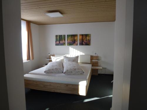 Schlafzimmer mit einem Bett mit weißer Bettwäsche und Kissen in der Unterkunft Ferienwohnungen Schäferhaus, incl MeineCardPlus in Willingen