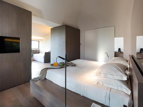 a bedroom with a large white bed and a tv at Zash Country Boutique hotel & SPA in Giarre