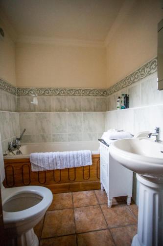 a bathroom with a tub and a toilet and a sink at Domvilles Farm self catering Courtyard Stable in Alsager