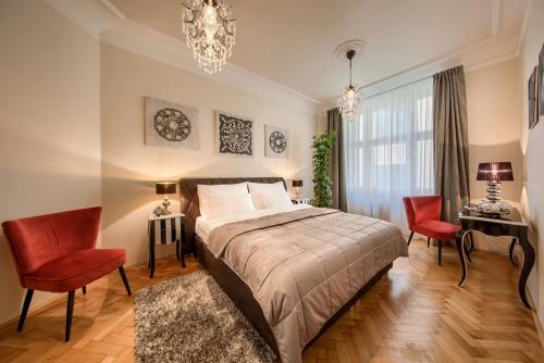 1 dormitorio con 1 cama, 2 sillas y lámpara de araña en PragueOne Apartment,A/C,Terrace, en Praga