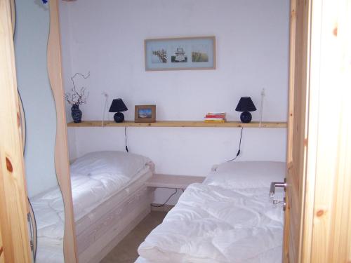 ein Schlafzimmer mit 2 Betten und einem Regal in der Unterkunft Bungalow Ungers Welt 1 in Ostseebad Nienhagen