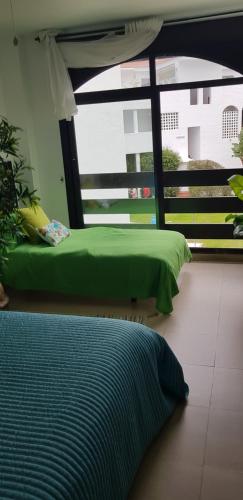 Un dormitorio con una cama verde y una ventana en Apartment Russell, en Marbella