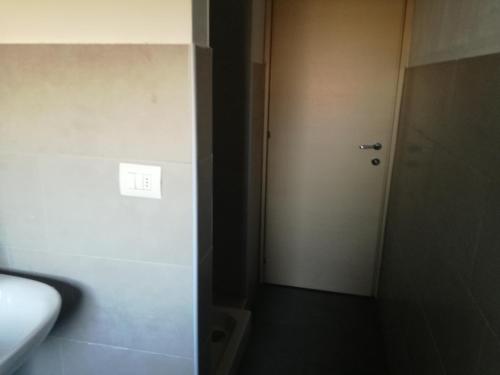 a hallway with a white door and a white wall at Via Sporting Mirasole in Opera