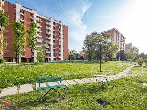 a park with two benches in the grass at Via Sporting Mirasole in Opera