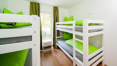 2 Etagenbetten in einem kleinen Zimmer mit grünen Kissen in der Unterkunft SEPPS IN in Billingsdorf
