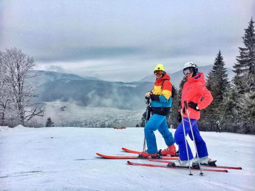 two people standing on skis on a snow covered slope at Kaštieľ Čičmany in Čičmany