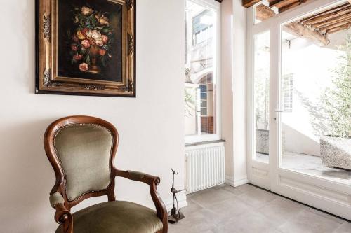 a chair in a room with a painting on the wall at Cortile in centro - Charm Suite Heart of Lucca in Lucca