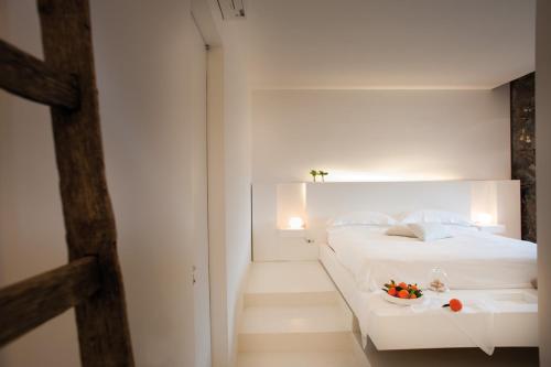 a bedroom with a white bed with a bowl of fruit on it at Zash Country Boutique hotel & SPA in Giarre