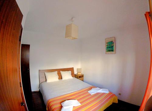 1 dormitorio con 1 cama con manta a rayas en Studio Martins, en Praia da Areia Branca