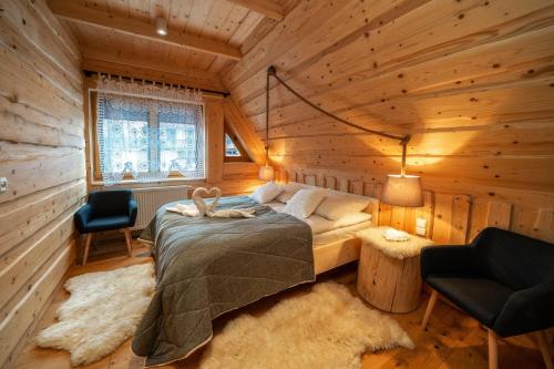 a bedroom with a bed in a wooden cabin at ZAKOPIANA in Zakopane
