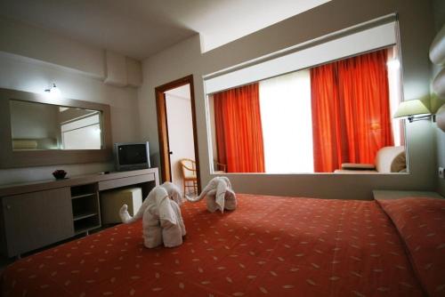 a hotel room with two elephants standing on a bed at Zorbas Beach Hotel in Tigaki