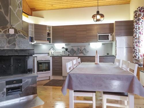 a large kitchen with a table and chairs in it at Holiday Home Immelkotsa 7 e by Interhome in Levi
