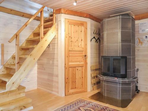 a room with a staircase and a fireplace in a cabin at Holiday Home Ruska by Interhome in Kyrö
