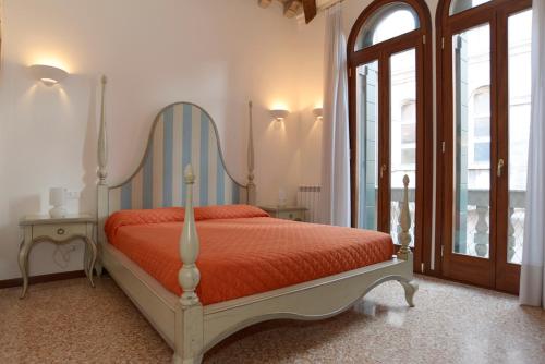 een slaapkamer met een bed met een rood dekbed bij Sunny Canal a/c wifi in Venetië
