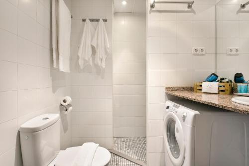 a bathroom with a toilet and a washing machine at Apartments Sata Olimpic Village Area in Barcelona