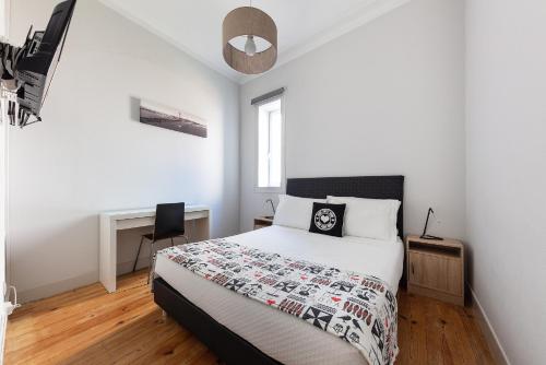 een witte slaapkamer met een bed en een stoel bij LX Sweet Home in Lissabon