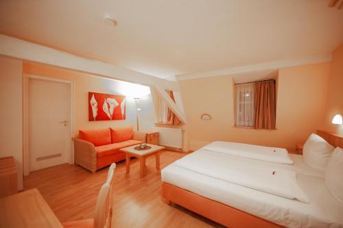 a bedroom with a large bed and a couch at Le Anfore in Bad Windsheim