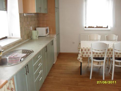 a kitchen with a table and a table and chairs at Domeček u Terčina Údolí in Nové Hrady