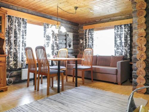 ein Esszimmer mit Tisch und Stühlen und einer Couch in der Unterkunft Holiday Home Luppo by Interhome in Kyrö