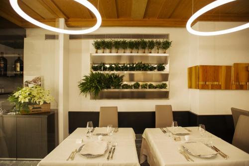 a dining room with two tables with white tablecloths at Palace Hotel Wellness & Beauty in Bormio