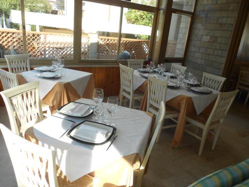 a dining room with white tables and white chairs at Hotel Ristorante La Terrazza in Lido di Camaiore