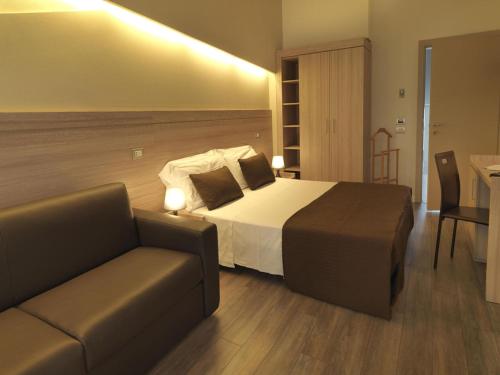 a hotel room with a bed and a couch at Hotel Villa Lalla in Rimini