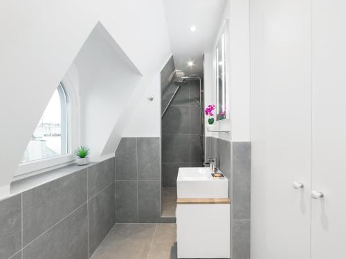 une salle de bain avec des toilettes blanches et un lavabo dans l'établissement LivinParis - Luxury AC 2 & 3 Bedrooms Le Louvre, à Paris