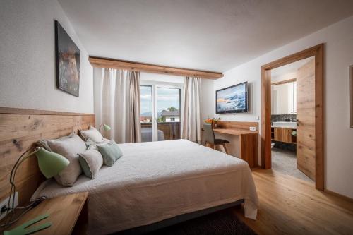 a bedroom with a bed and a desk and a window at Luxus Wohnung Living 9 in Walchsee