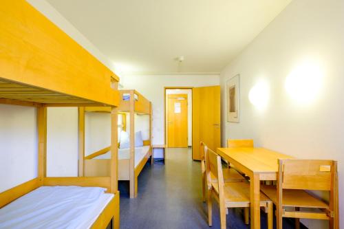 a room with a dining table and bunk beds at Internationales Jugendgästehaus Dachau in Dachau