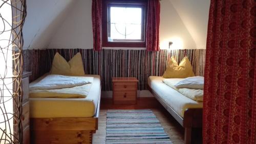 two beds in a room with a window at Almhütte Ödenhübl in Katschwald