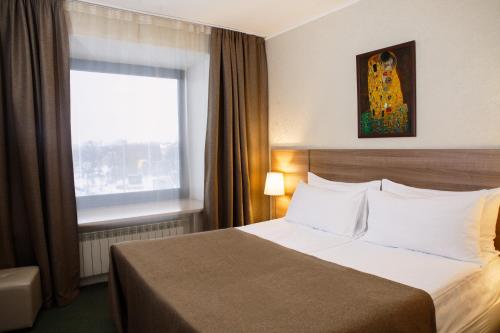 a hotel room with a bed and a window at Moscow Hotel in Saint Petersburg