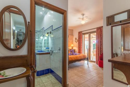 ein Bad mit einer Dusche, einem Waschbecken und einem Spiegel in der Unterkunft Portocolom - 269438 in Portocolom