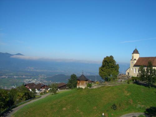 a house on top of a green hill at Land- & Panoramagasthof Schöne Aussicht in Viktorsberg