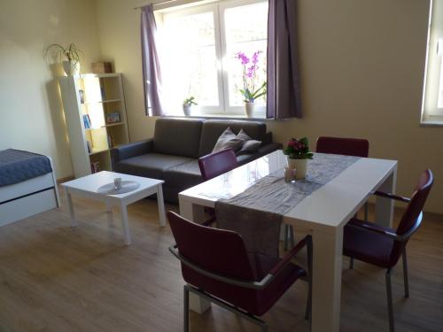 a living room with a table and a couch at Cafe und Pension Blohm in Greifswald