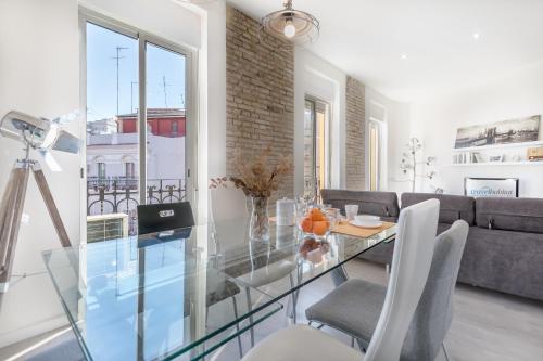 una mesa de cristal y sillas en la sala de estar. en Travel Habitat Ruzafa Apartment, en Valencia
