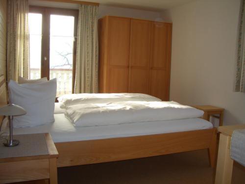 Schlafzimmer mit einem großen Bett und einem Fenster in der Unterkunft Land- & Panoramagasthof Schöne Aussicht in Viktorsberg