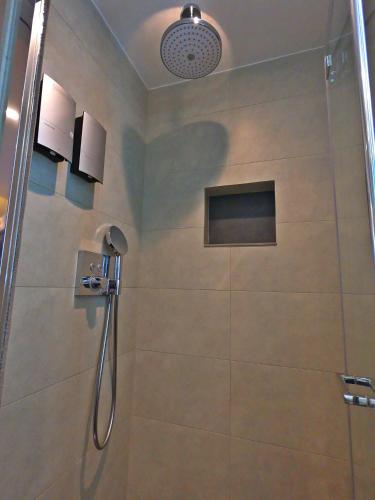 a shower with a glass door in a bathroom at Best Western Plus Delmere Hotel in London