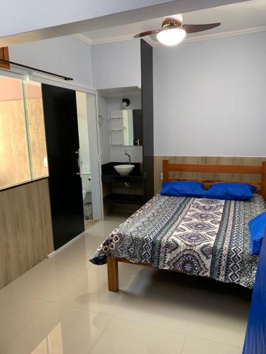 a bedroom with a bed and a bathroom with a sink at CASA PÔR DO SOL 1 in Arraial do Cabo