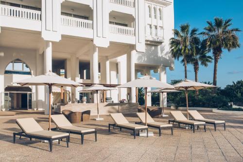 a group of chairs and umbrellas in front of a building at Iberostar Selection Kantaoui Bay in Port El Kantaoui