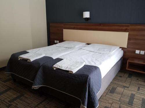 a bedroom with a bed with two towels on it at Centrum Promocji Leśnictwa w Mucznem in Lutowiska