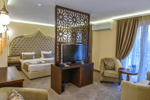 a hotel room with a bed and a television at Sahara Hotel in Svilengrad