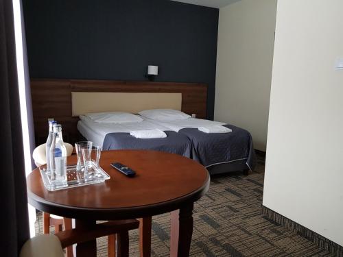 a hotel room with a bed and a table with drinks at Centrum Promocji Leśnictwa w Mucznem in Lutowiska