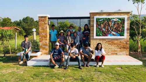 a group of people posing for a picture in front of a painting at Panutsaya Homestay in Wang Nam Khieo