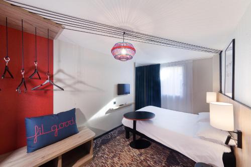a bedroom with a white bed and a table at ibis Styles Toulouse Lavaur in Lavaur