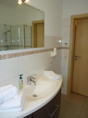 a bathroom with a sink and a mirror at Cafe und Pension Blohm in Greifswald