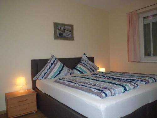 a bed with two pillows on it in a bedroom at Cafe und Pension Blohm in Greifswald