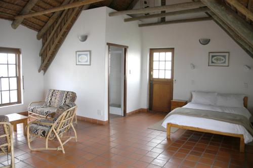una camera con letto e sedia di Arniston Seaside Cottages a Arniston