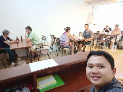a man sitting at a table in a restaurant at Savet Guesthouse in Stœ̆ng Trêng
